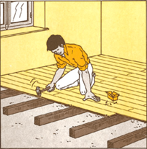 Homme agenouillé posant un parquet en bois clair avec un marteau sur des lattes. Une boîte de clous est à côté de lui.