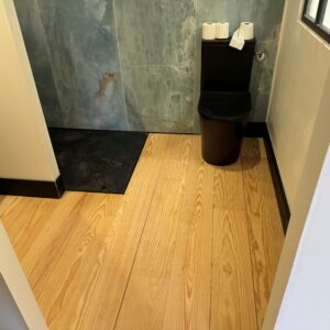 Parquet massif en pin maritime sans noeud largeur 200mm avec plinthes moulurées peintes en noir